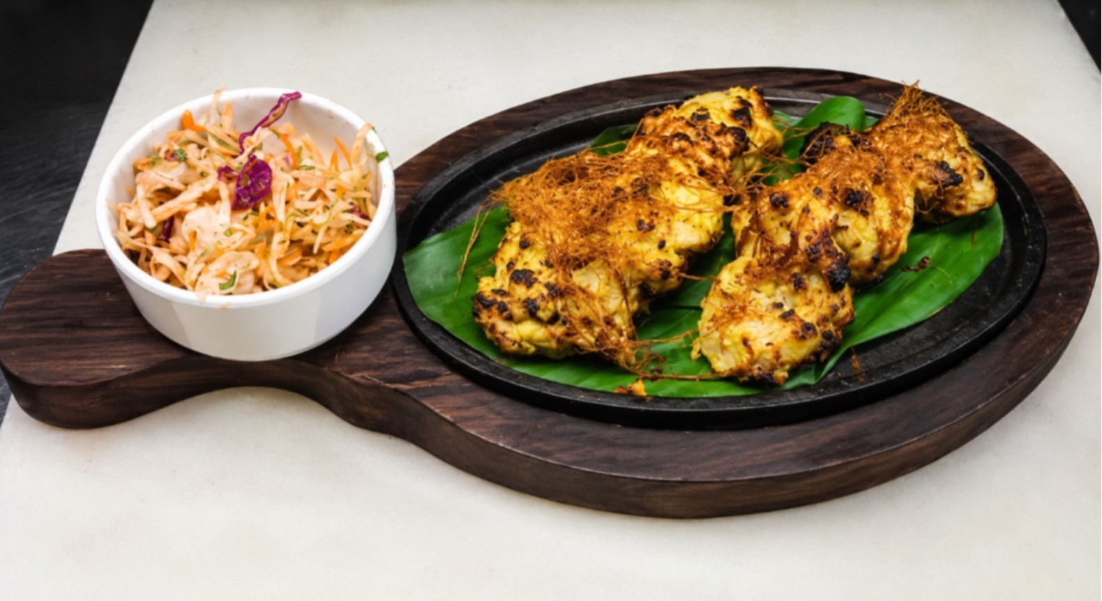 Tandoori grill platter featuring charred kebabs and tikka pieces served on sizzling plate at Big Bull Cafe